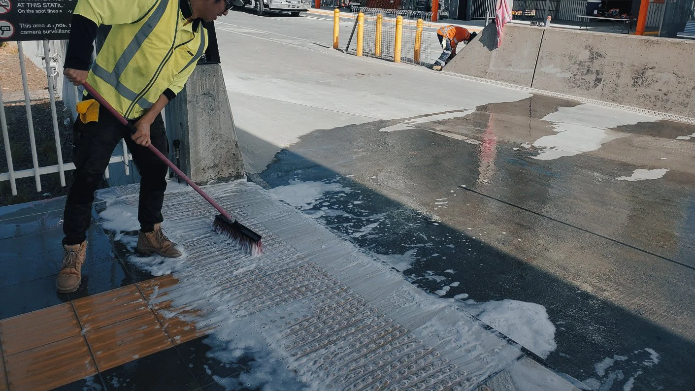 Scrub Hub workers cleaning a concrete entrance