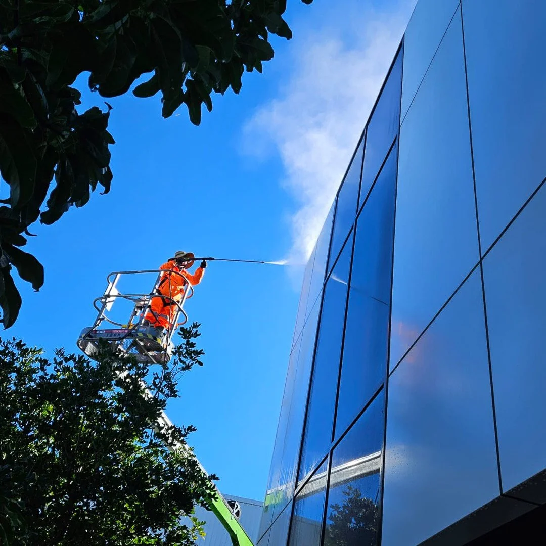 Scrub Hub team pressure washing a blue building exterior