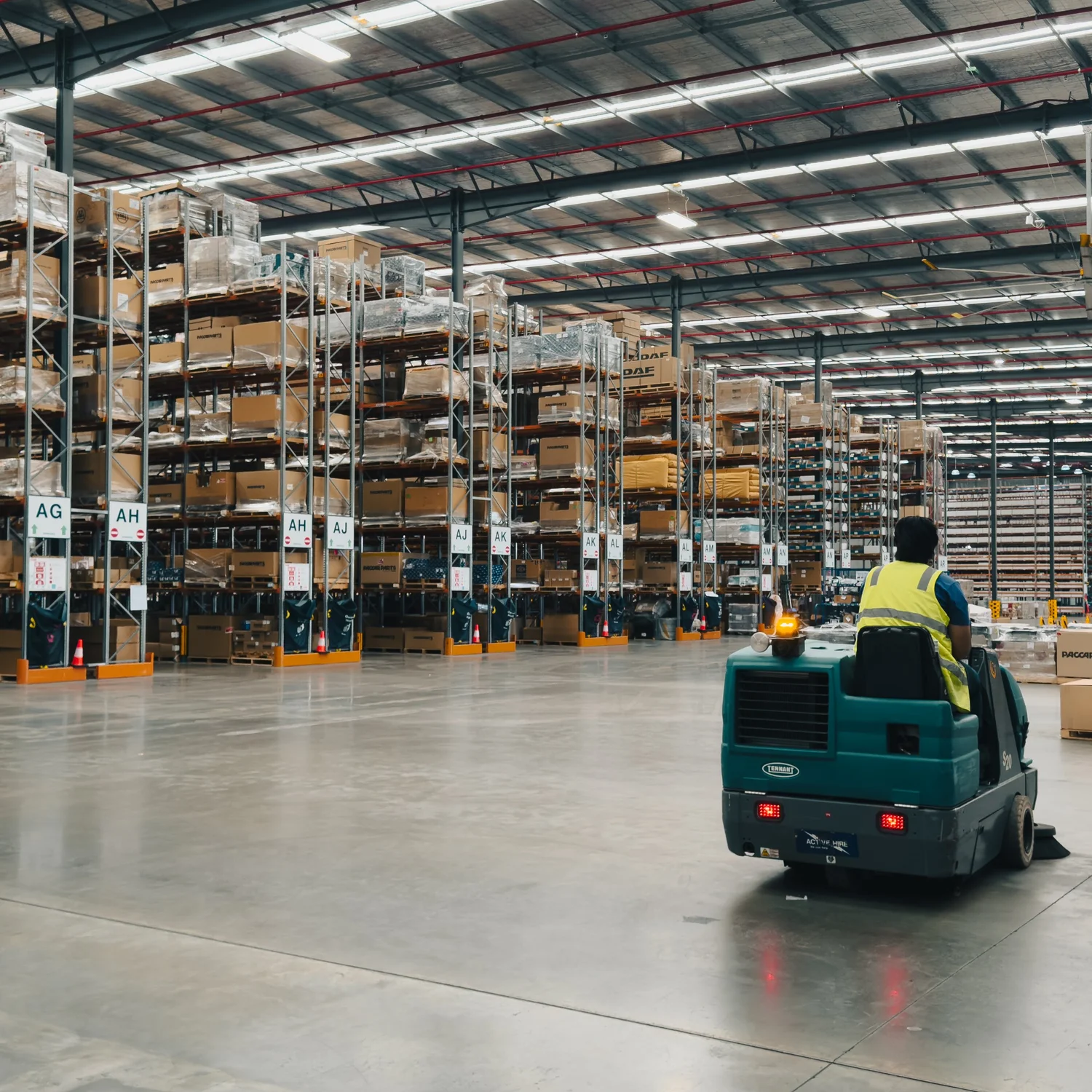 Machine scrubbing a warehouse floor